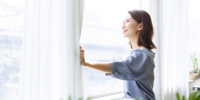 カーテンを開ける女性
